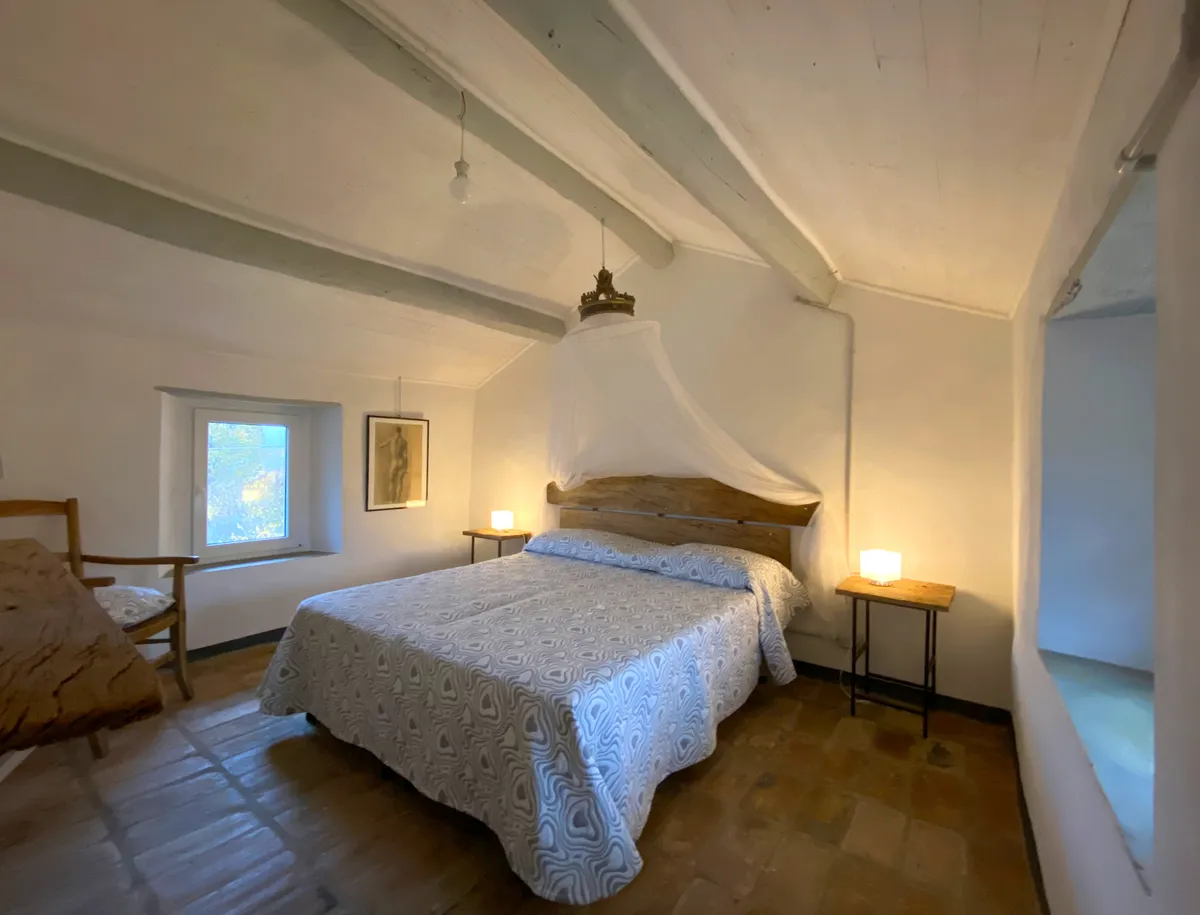 Camera matrimoniale con letto in legno e baldacchino