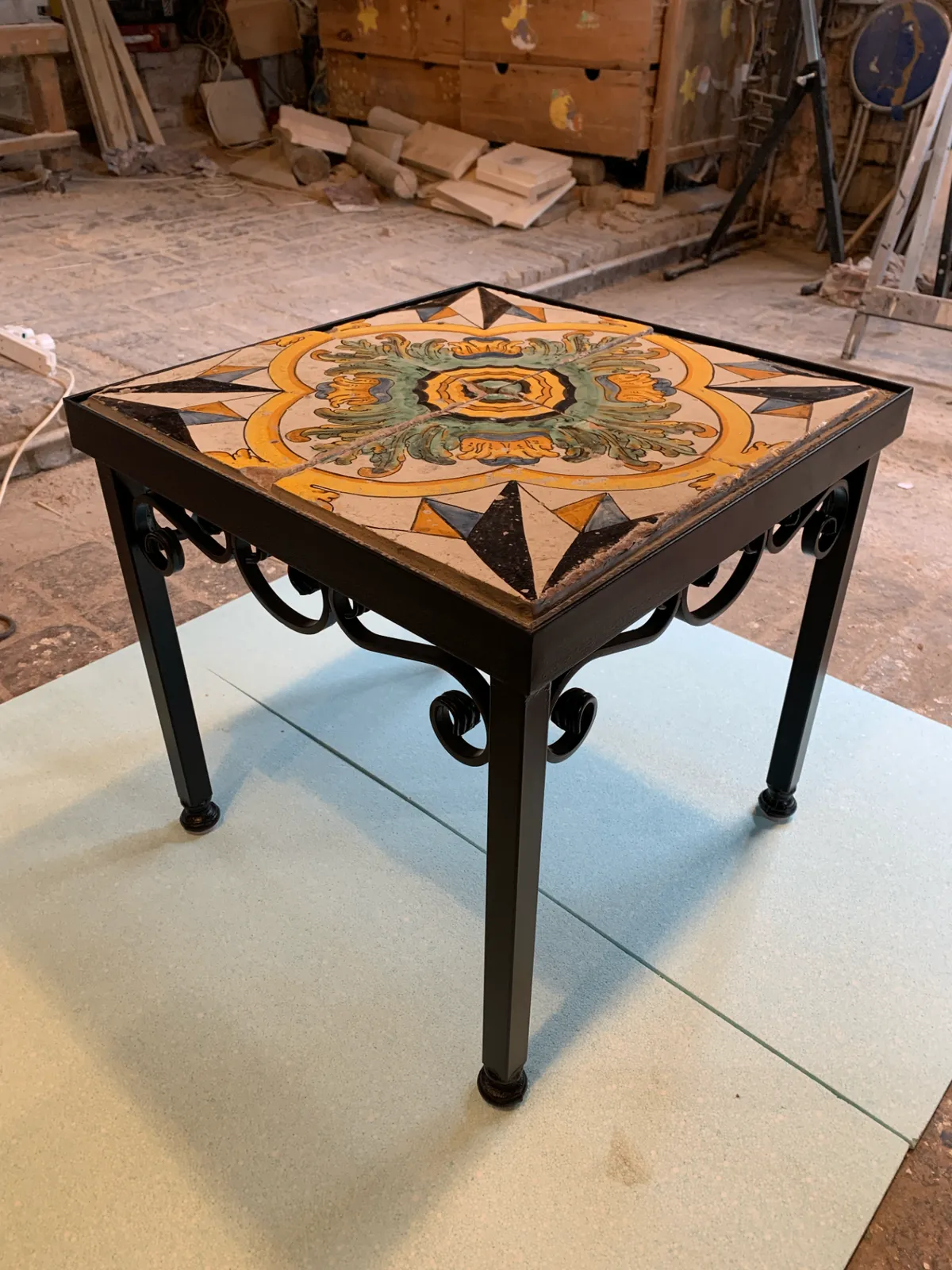 Tavolino in ferro battuto con piano in maiolica
